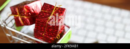 Basket with gifts is on table near keyboard and credit card Stock Photo