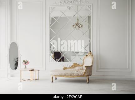 Old fashioned sofa in classic light interior with big mirror Stock Photo