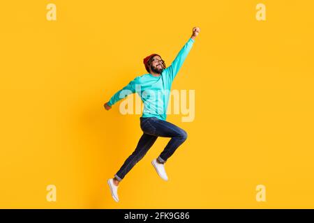 Full body profile side photo of young african man happy positive smile jump up superhero isolated over yellow color background Stock Photo