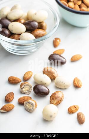 Sweet chocolate almonds. Chocolate eggs on white table. Stock Photo