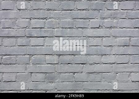 The bright texture of the old brick wall is completely painted with gray paint. A high resolution. Stock Photo