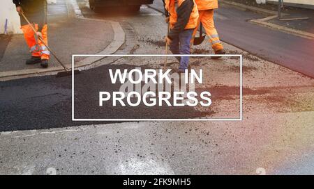 Text "work in progress" with workers as background. Stock Photo