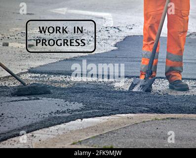 Text "work in progress" with workers as background. Stock Photo