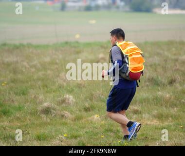 off duty Gurkha with weighted back pack on a training and fitness run across Salisbury Plain military training area Stock Photo