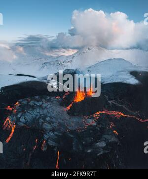 Aerial Panorama of active lava river flows from a volcanic eruption in mount Fagradalsfjall Geldingadalir valley, Southwest Iceland. Blue sky with Stock Photo