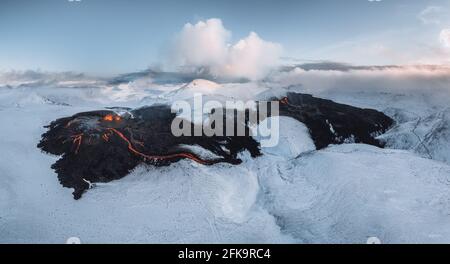 Aerial Panorama of active lava river flows from a volcanic eruption in mount Fagradalsfjall Geldingadalir valley, Southwest Iceland. Blue sky with Stock Photo