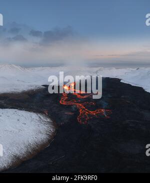 Aerial Panorama of active lava river flows from a volcanic eruption in mount Fagradalsfjall Geldingadalir valley, Southwest Iceland. Blue sky with Stock Photo