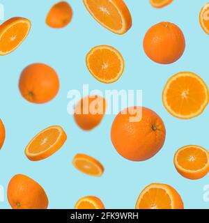 Creative idea with fresh orange sliced on pastel blue background. Minimal fruit concept.Vitamins, healthy diet concept. Sliced and whole orange floati Stock Photo