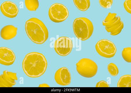 Floating levitating fresh lemon on pastel blue background. Vitamins, healthy diet concept. Minimal fruit idea. Sliced lemon floating in the air. Creat Stock Photo