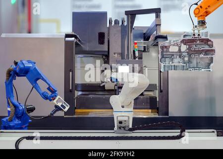 Industrial robotic gripping and robotic 3D scan working on teamwork with engine parts of motorbike in CNC machine on smart factory, industry 4.0 Stock Photo