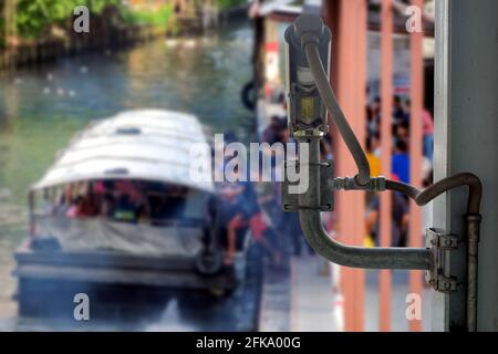 Rear view of CCTV cameras that installed on overpass for assist to monitor safety of blurred group people who are using passenger boats for travel Stock Photo