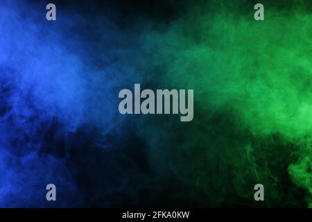 Smoke in blue green light on black background Stock Photo