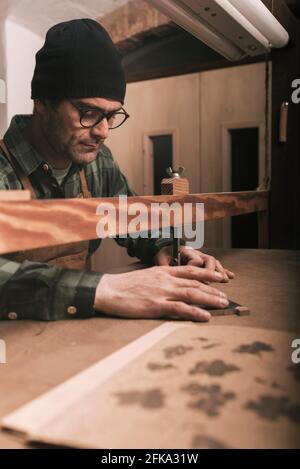 Cabinetmaker working on a wooden ornament with scroll saw. Stock Photo