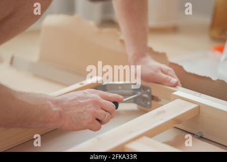 House furniture assembly process, hands of a man with a screwdriver