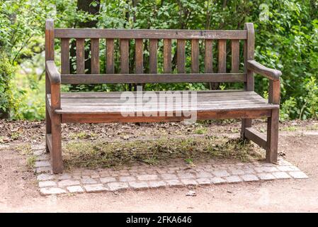 Old wooden bench. Cozy bench in a green corner near the path. A bench under the walls of the castle of Brno in the Czech Republic. Stock Photo