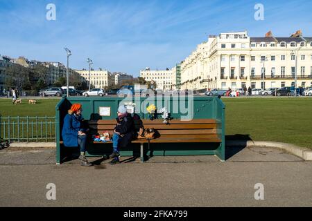 Two Women Chatting On A Bench On Brighton Seafront, Brighton, East Sussex, UK. Stock Photo
