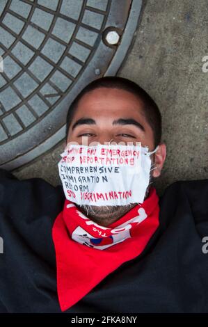 A man wearing a mask with messages about the Swine flu and immigration policies protests during the 2009 Mayday protests in Downtown Los Angeles, CA. Stock Photo