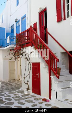 White building with red doors and windows and blue in background, Mykonos, Greece Stock Photo