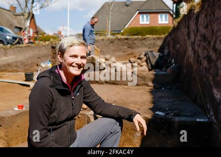 Norddorf, Germany. 28th Apr, 2021. Excavation leader Janna Kordowksi kneels in front of a pit. In Norddorf on Amrum, a team from the Schleswig-Holstein State Archaeological Office is excavating a burial mound with the Frisian proper name 'Naiarhuuch' (Norddorf LA 12) in advance of a construction project. The work is scheduled for completion in May 2021. Credit: Frank Molter/dpa/Alamy Live News Stock Photo
