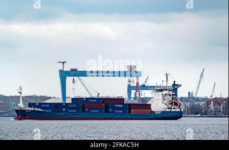Kiel, Germany. 21st Apr, 2021. The container ship 'Anja' passes the German Naval Yards shipyard on the fjord. The gross domestic product (GDP) is calculated by the Federal Statistical Office, it is a measure of the economic performance of a national economy. Credit: Axel Heimken/dpa/Alamy Live News Stock Photo