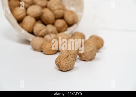 Walnuts in a wicker basket on a white background. Stock Photo