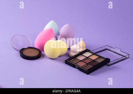 different colors of beauty blender, blush and eyeshadow Stock Photo