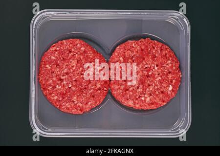 Raw round burger patties in package on dark background Stock Photo
