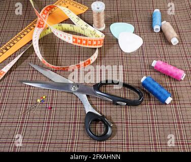 Tailor equipment, tools,  including tape, chalk, thread, scissors and on woolen piece of fabric. Stock Photo