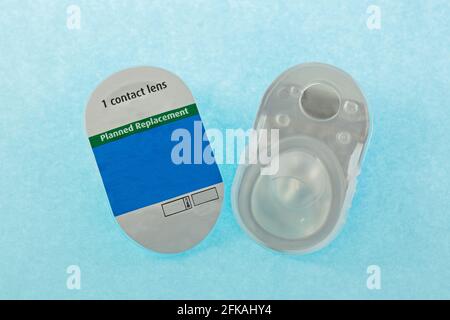 A pair of brand new monthly disposable contact lens packages on blue background Stock Photo