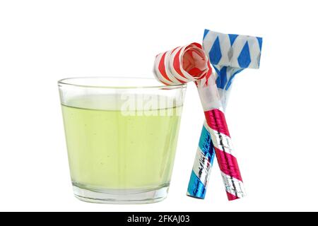 A glass of orange flavored effervescent tablets dissolving in water next to party blowers ideally to cure a hangover Stock Photo