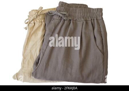Pants made of cotton. Folded trousers in light dark brown, natural fabric cloths isolated on white background Stock Photo