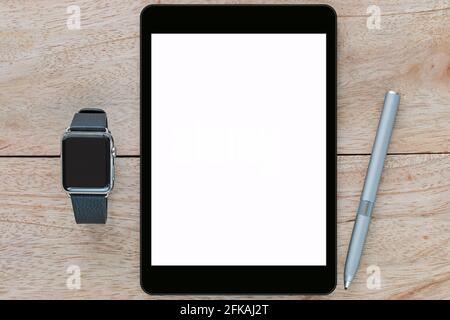 Smart watch with leather bands, black tablet computer with white blank screen and thin-tip stylus pen on wooden background Stock Photo
