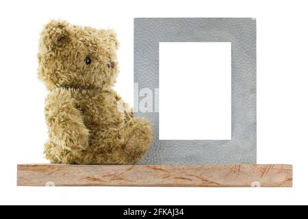 Side profile of a cute bear sitting next to blank metal picture frame made of real silver, isolated on white background Stock Photo