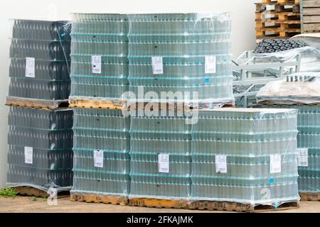 glass wine bottles wrapped in plastic and stacked up outdoors concept wine industry in South Africa Stock Photo