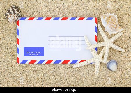 Blank classic air mail envelope on the sand decorated with sea shells and Starfish Stock Photo