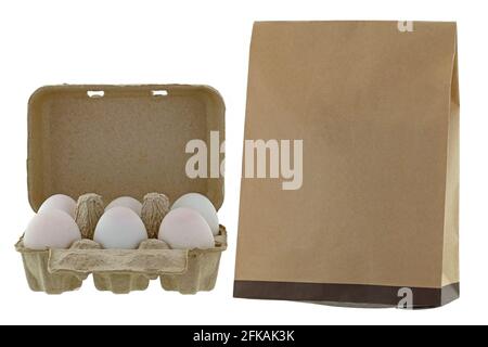 Paper pulp egg tray packages of fresh eggs next to brown recycled paper bag isolated on white background Stock Photo