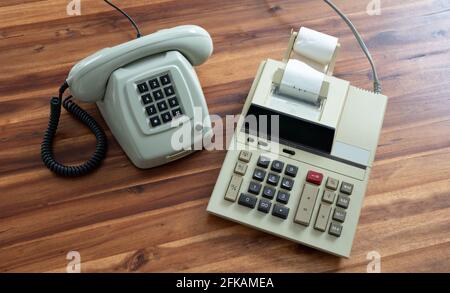 Old fashioned calculator and telephone on desk Stock Photo