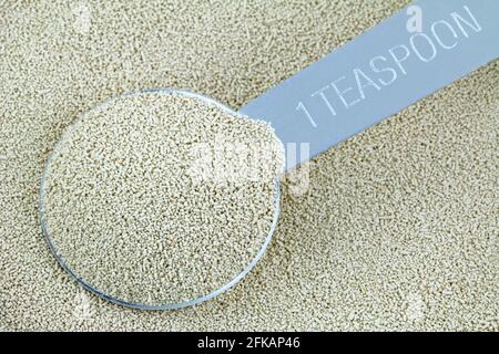 Closeup of a spoonful of active dry Baking yeast granules Stock Photo