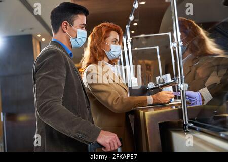Tourists paying for the room they have booked online Stock Photo