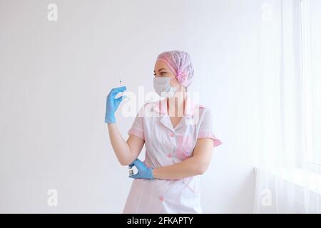 Doctor or nurse hand in blue gloves holding covid-19 vaccine disease preparing for child, baby, adult, man and woman vaccination shot, medicine and dr Stock Photo