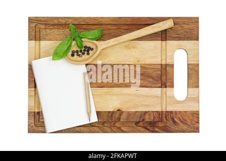 Top view of a small blank notebook with pencil, wooden spoon on a new wooden cutting board isolated on white background Stock Photo