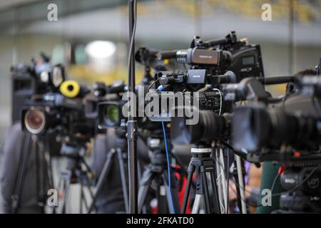 Bucharest, Romania - April 25, 2021: Shallow depth of field (selective focus) image with TV cameras on tripods on a press event. Stock Photo