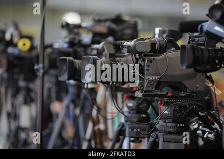 Bucharest, Romania - April 25, 2021: Shallow depth of field (selective focus) image with TV cameras on tripods on a press event. Stock Photo