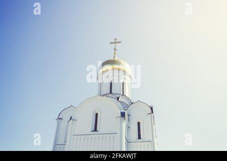 Eastern orthodox crosses on gold domes (cupolas) againts blue sky with clouds Stock Photo