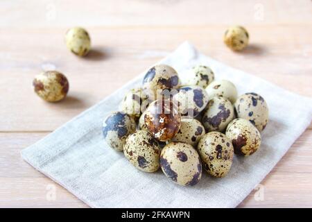 Quail eggs on the white napkins on the rustic background. Concept healthy food. Stock Photo