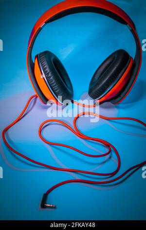 Closeup Photo of a Big Red Headphones on the Table. Stylish Accessory for Dj. Music Fan. Equipment for a Home Schooling. Photo with Copy Space. Stock Photo