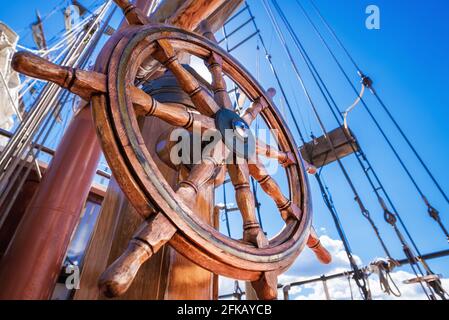 steering wheel of a sailboat against a blue sky Stock Photo