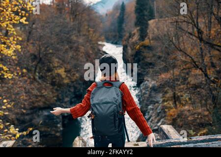woman hiker stands on the bridge near the river mountains travel Stock Photo