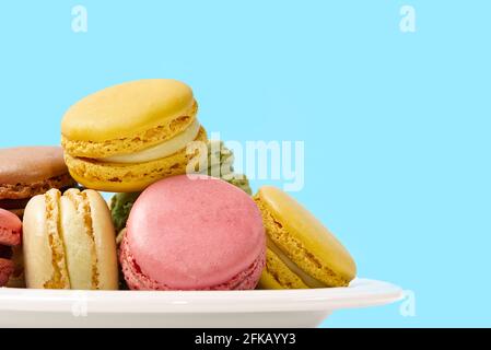French dessert macaron isolated on blue background. Modern Macarons on colorful background. Stock Photo