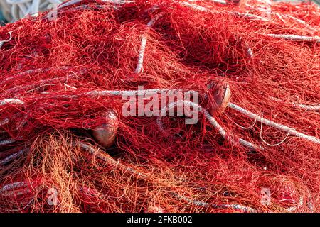 Red fishing nets with floats and ropes. Still-life shot, perfect image for aquaculture, intensive fishing and environmental protection.
